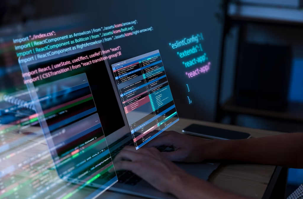 person typing on laptop, the phone on the right side of table, and coding background